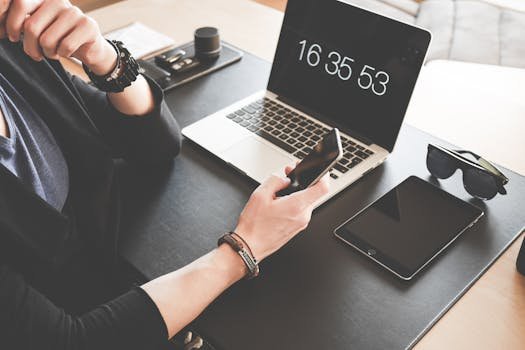A modern workspace featuring a laptop, smartphone, tablet, and sunglasses, illustrating digital connectivity.